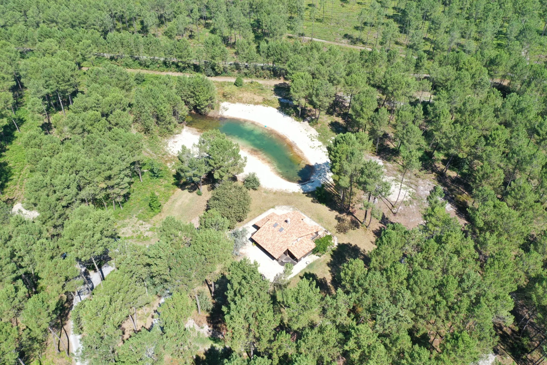 Vue aérienne du domaine landais, de ses bâtiments et de son plan d’eau entouré d’arbres